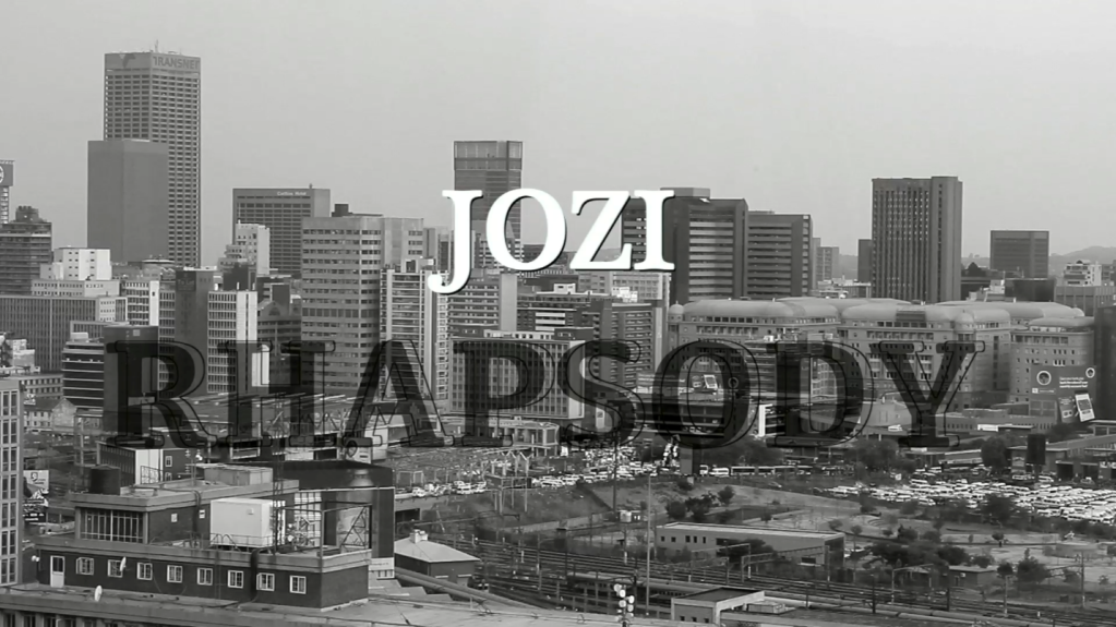 A black-and-white photograph of the Johannesburg city skyline, overlaid with the text, JOZI RHAPSODY.